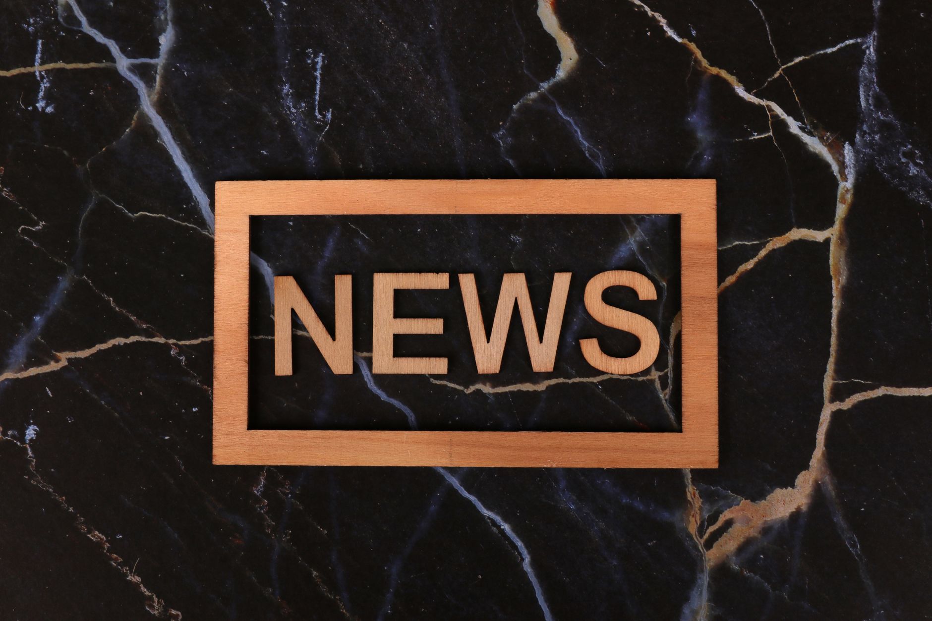 Wooden text of 'news' outlined on a dark, marbled surface, creating a striking contrast. — Detaillierte Analyse der Spielausw