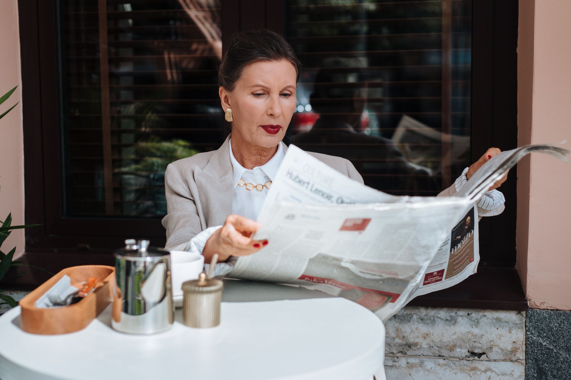 Sophisticated woman enjoying her morning newspaper at a cozy outdoor cafe. — DuxCasino Quick Wins: Fast Slots, Rapid Rewards
